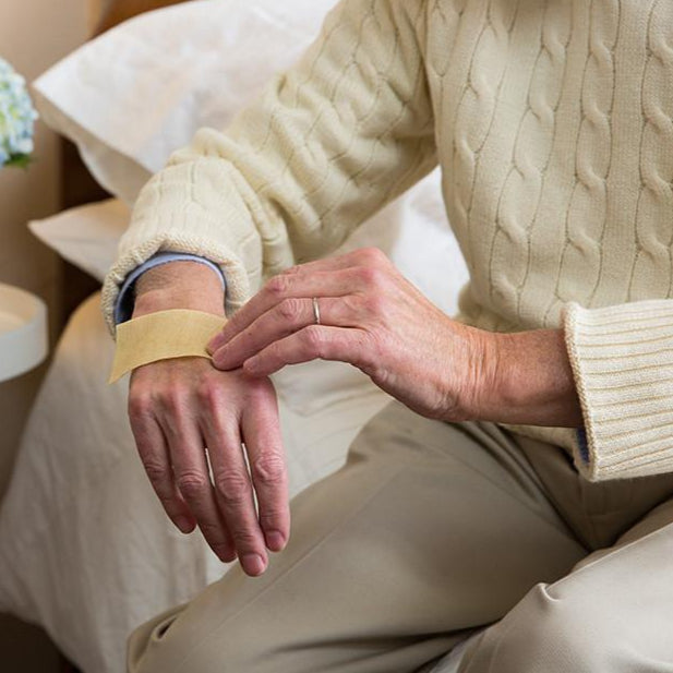 Person applying ManukaHD bandage to their hand